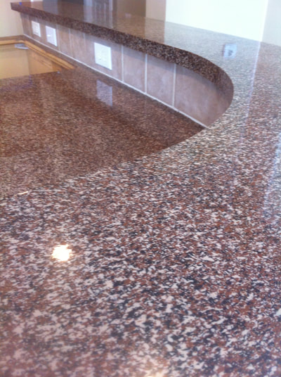 Picture of countertop after resurfacing. You can see a countertop island resurfaced with red, white, black speckled pattern. 