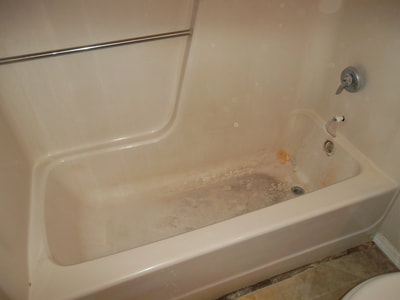 Picture of a dirty looking, moldy fiberglass tub. Even the walls are dirty and have caulk and mold. 