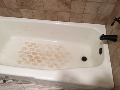 Picture of a bathtub that needs reglazing. On the bottom you can see the dirt accumulated. 