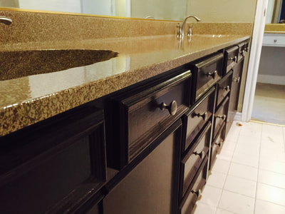 A picture of a bathroom countertop. The cabinets are dark brown and the refinished countertop is sedona colored.