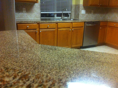 This image shows the Bronze Gravel countertop color on a kitchen countertop. You can see a Kitchen with light brown tiles and cabinets with a refinished Bronze Gravel countertop. 