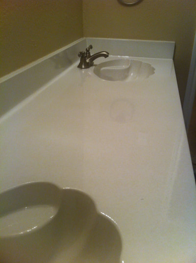 Picture of a double sink bathroom countertop. You can see a shell countertop and sink that has been refinished using the White Dust color option. 