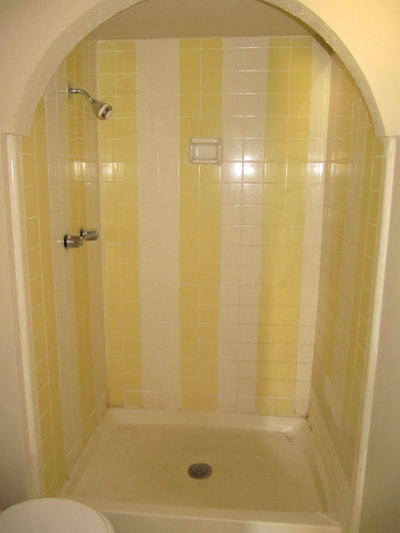 Picture of an outdated shower design. You can see yellow and white  shower tile. 
