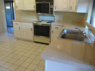 Picture of a newly restored kitchen. You can see a primarily white kitchen design with the Lucid Pebble countertops. 