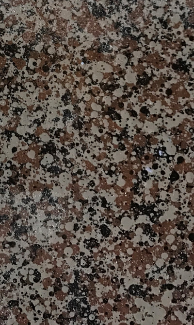 Image of a bronze gravel countertop finish. You can see bronze, black and cream colored spots.