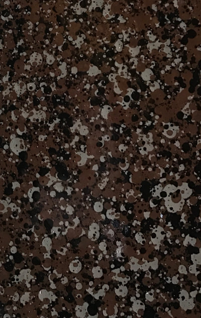 Picture of a Red Ash countertop surface. You can see dominant red surface with back and grey spots