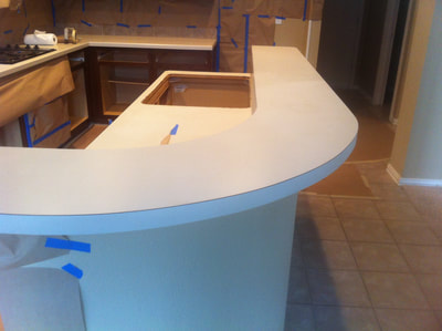 In this image you can see a plain white countertop before a countertop resurfacing. 