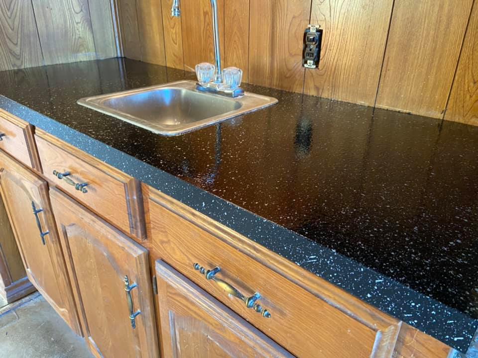 Picture of the newly refinished countertop after applying fresh coat. You can see a fresh layer of black with speckles of white. 