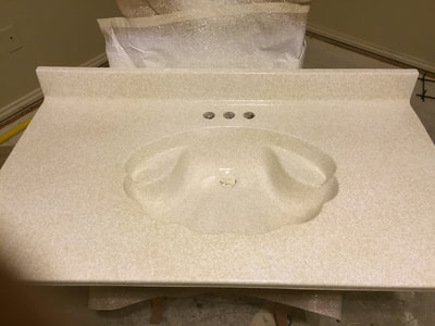 This is a picture showing a shell porcelain sink that has been refinished with the Lucid Pebble color pattern. You can see the shell shaped porcelain sink that has just gotten refinished.