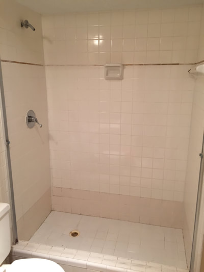 Picture of a outdated shower. The tiles are old, dull and could use refinishing. 