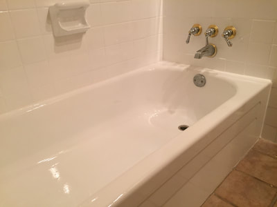 A picture of a bathtub that has been refinished. Also the tiles are redone and the bathroom looks modern and attractive. 