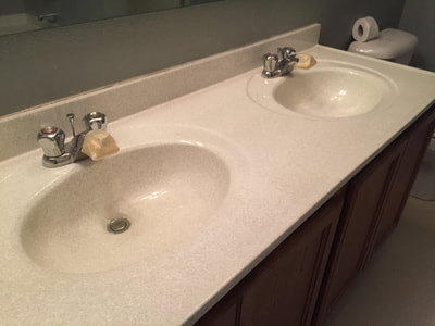 Picture of a double sink vanity top resurfaced with the Lucid Pebble pattern. You can see sink and bathroom countertop refinished with Lucid Pebble. 