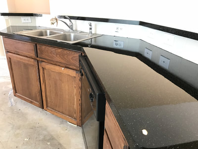 This image shows a kitchen countertop resurfaced with the Sable Stone color pattern. You can see a sink, cabinets, and countertop. 