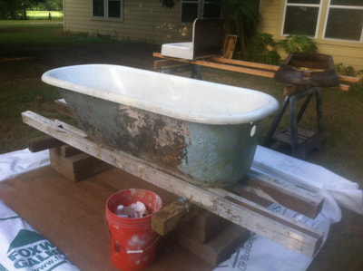 Picture of a claw foot tub that is rusty looks dirty. 