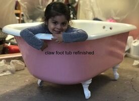 Picture of a bathtub resurfacing job in dallas. You can see a Pink claw foot bathtub with a small child  sitting in the tub smiling  at the camera. 
