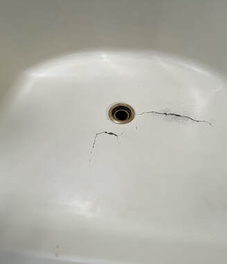 Picture of a cracked bathtub that is in need of a resurfacing job. 