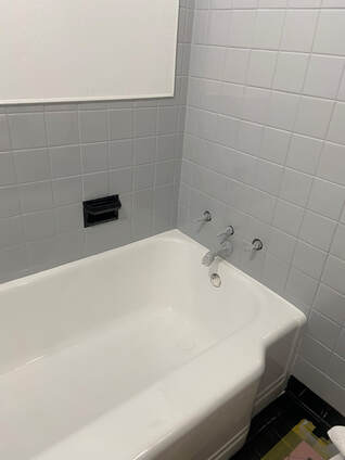 Picture of repaired bathtub. You can see the refinished white bathtub .