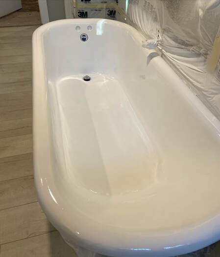 Picture of a bathtub that is in the process of a bathtub resurfacing project. The surroundings are protected as it is now time to apply the different coatings of plaster. 