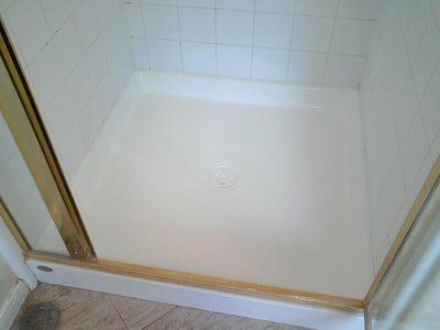 Picture of a shower pan that has no rust or dirty spots left, after the refinish. 
